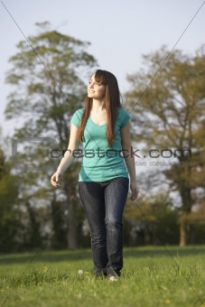 Teenage Girl Walking Through Summer Meadow