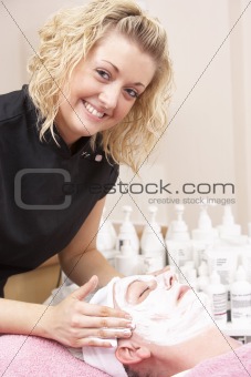Female masseuse giving client facial