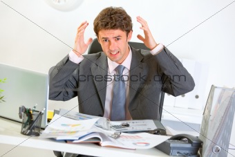 Confused modern businessman lost in documents

