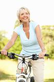Portrait of mature woman riding cycle in countryside
