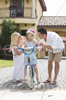 Family WIth Girl Riding Bike & Happy Parents 
