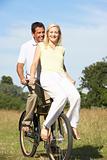 Young couple riding bike in countryside