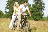 Couple riding tandem in countryside