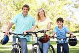 Parents And Son On Cycle Ride In Park