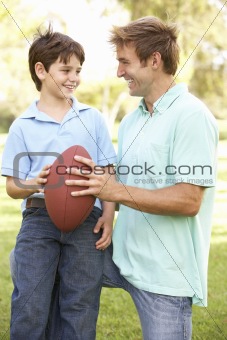 Father And Son Playing American Football Together