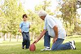Grandfather And Grandson Playing American Football Together