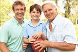 Grandfather With Father And Son Playing American Football Together