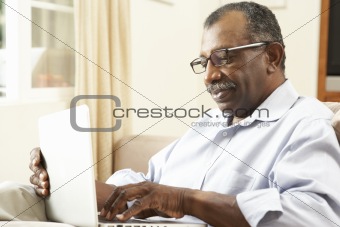 Senior Man Using Laptop At Home