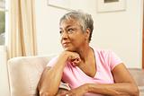 Senior Woman Looking Thoughtful In Chair At Home