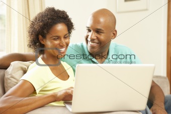 Couple Using Laptop At Home