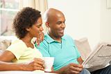 Couple Relaxing At Home With Newspaper