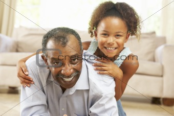 Grandfather And Granddaughter Playing Together At Home