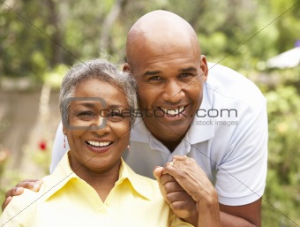 Senior Woman Being Hugged By Adult Son