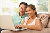 Young Couple Using Laptop At Home