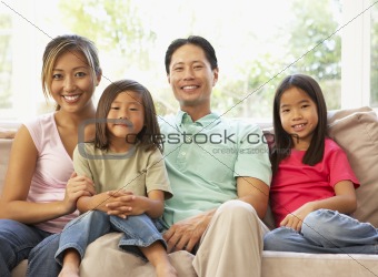 Young Family Relaxing On Sofa At Home
