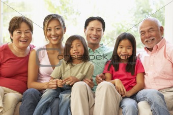 Extended Family Relaxing On Sofa At Home Together
