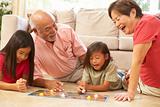 Grandparents And Grandchildren Playing Board Game At Home