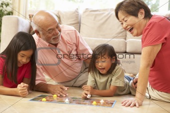 Grandparents And Grandchildren Playing Board Game At Home