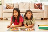 Two Children Playing Board Game At Home