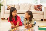 Two Children Playing Board Game At Home