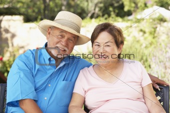 Senior Couple Relaxing In Garden Together
