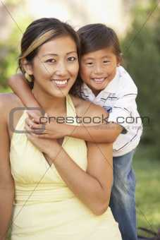 Mother And Son Hugging In Garden