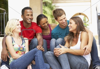 Group Of Friends Sitting On Steps Of Building