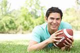 Portrait Of Young Man In Park With American Football