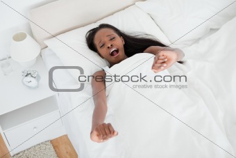 Tired woman stretching her arms and yawning
