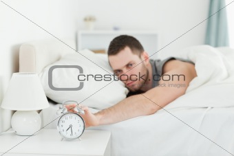 Man being awakened by an alarm clock