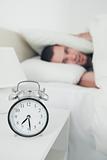 Portrait of an attractive young man covering his ears while his alarm clock is ringing