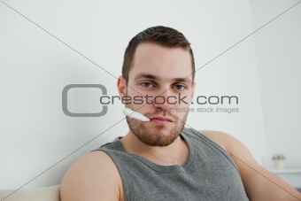 Sick man posing with thermometer