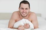 Smiling man lying on his bed