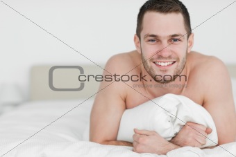 Smiling man lying on his belly