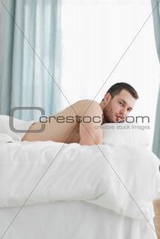 Portrait of a calm man lying on his belly