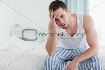 Depressed man sitting on his bed