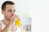Portrait of a good looking man drinking orange juice