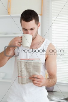 Portrait of a man drinking tea while reading the news
