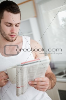 Portrait of a man drinking orange juice while reading the news