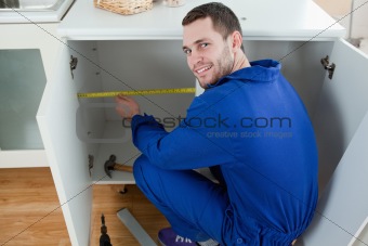 Smiling repair man measuring something