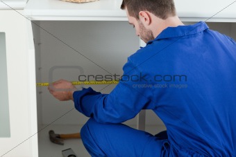 Focused repair man measuring something