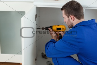 Young handyman fixing a door