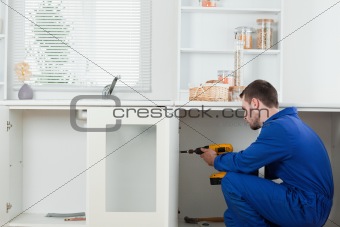 Handsome handyman fixing a door