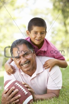 Grandfather With Grandson In Park With American Football