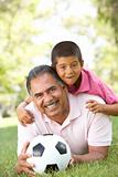 Grandfather With Grandson In Park With Football