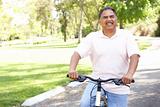 Senior Man Riding Bike In Park