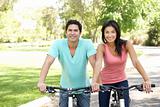 Young Couple Riding Bikes In Park