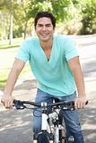 Young Man Riding Bike In Park