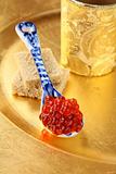 Fresh red caviar  in  spoon  on gold background