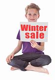 boy holding white page with winter sale word